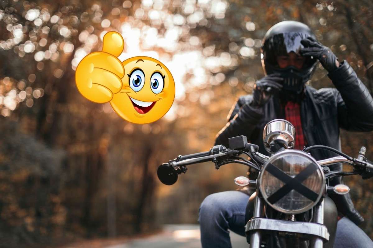 Una persona in moto e in alto a sinistra l'emoticon con il pollice su