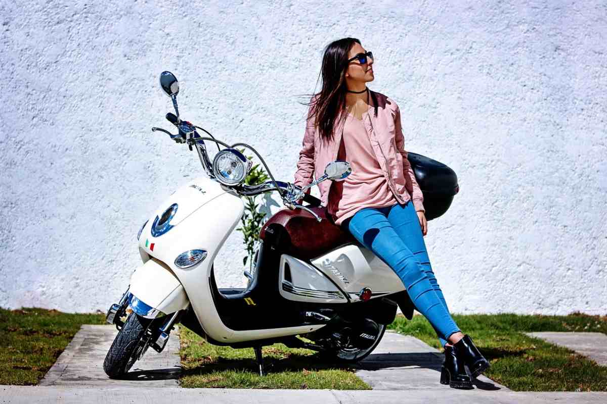 Uno scooter e una donna seduta sulla sella 