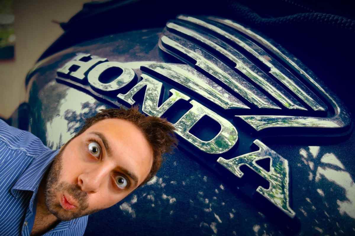 Il serbatoio di una Honda con la scritta e il logo e in basso a sinistra un uomo stupito