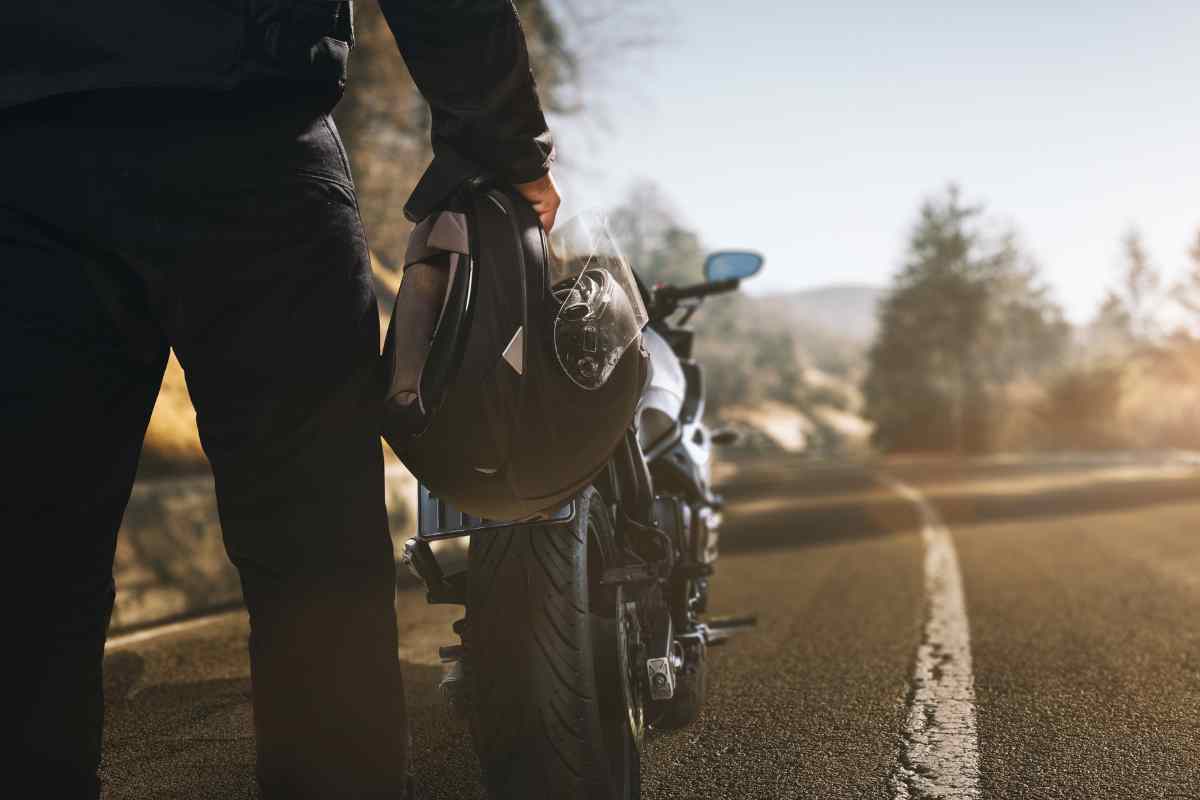 Motociclista con il casco in mano 